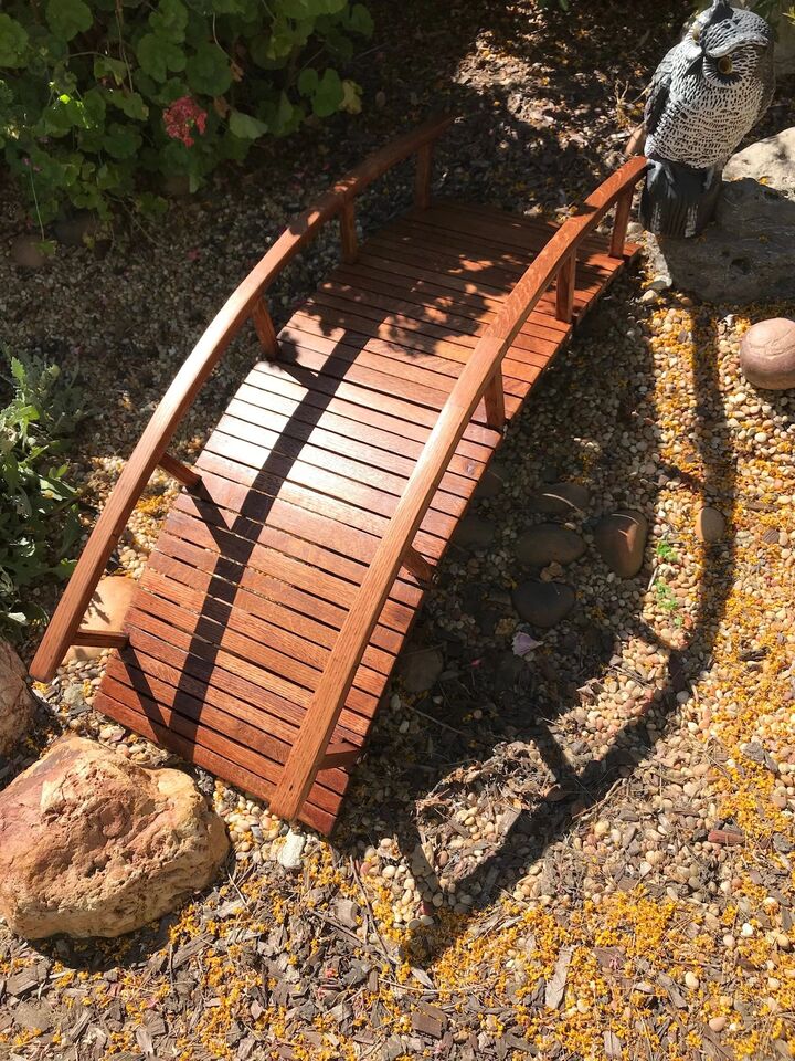 Side view of the arched garden bridge showing the curve of the stringers over the rocks