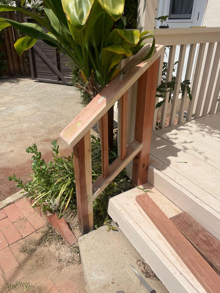New timber handrail and step framing at the side of a porch beside a planted border