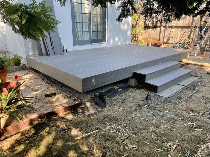 Grey deck and steps in a back garden with the surrounding ground not yet reinstated