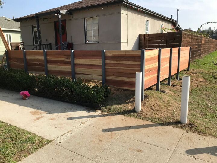 Front yard horizontal redwood fence with posts set at intervals along the sidewalk
