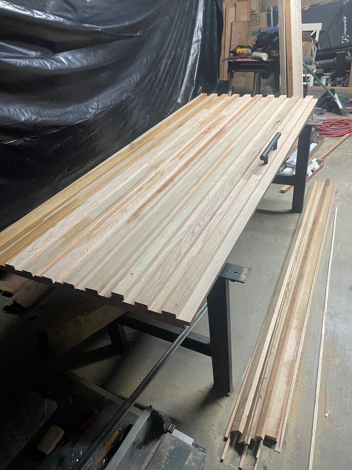 Timber boards clamped in a glue-up on the workbench during a table top build