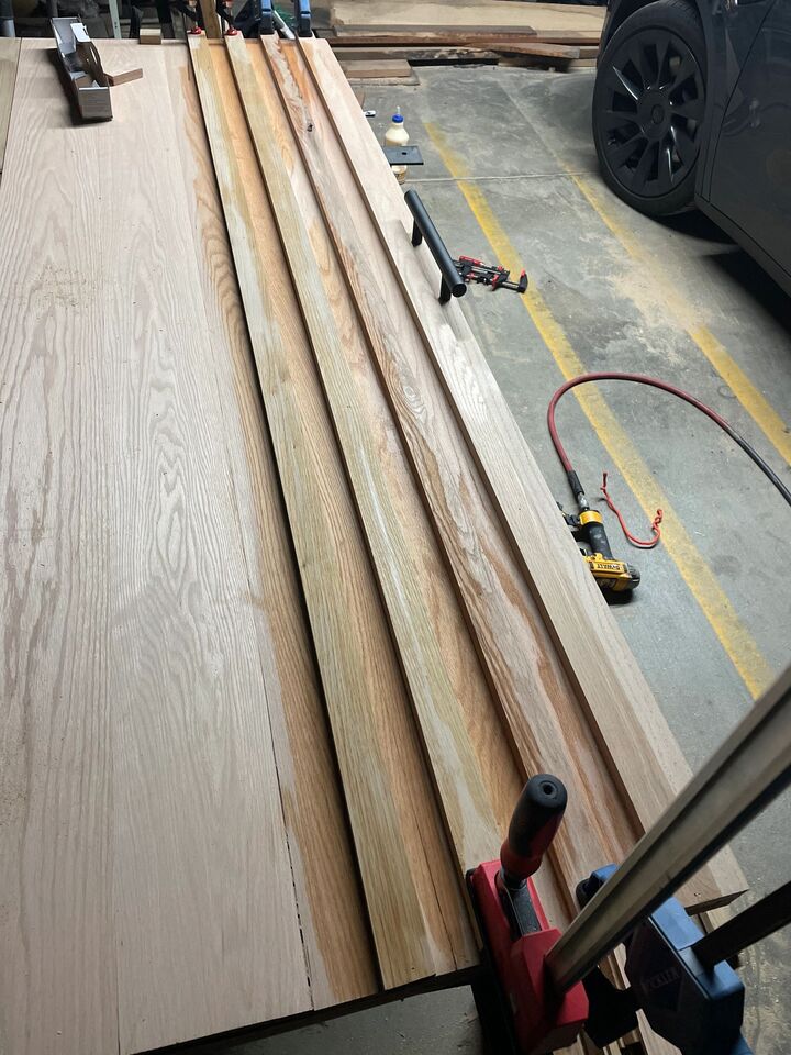Long timber boards laid out and clamped on a driveway ready for machining