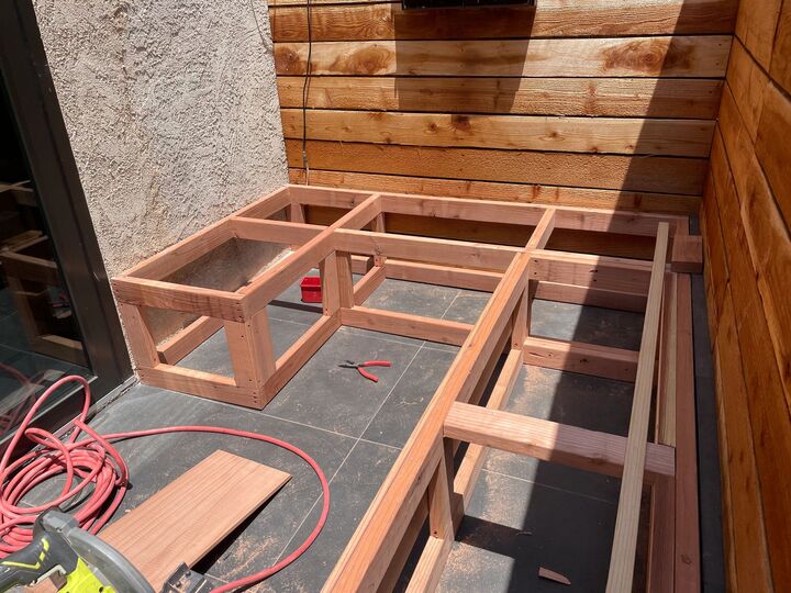 Open redwood bench framing viewed from above, showing the internal storage bays before the seat panels go on