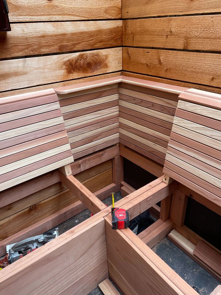 Redwood bench corner under construction with the back cladding installed and the seat structure still open