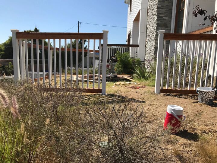 White picket gate and fence section installed at the side of a house